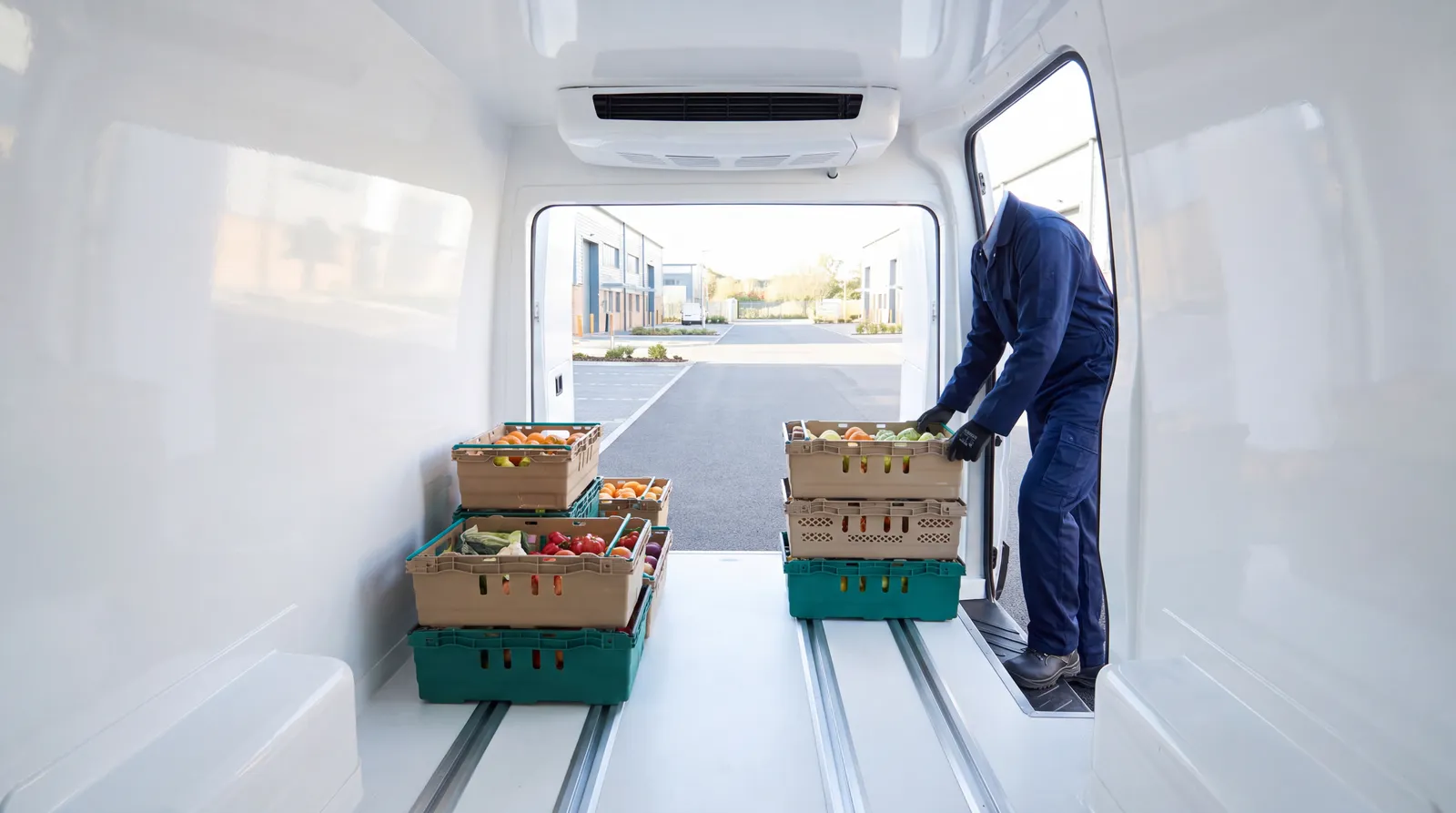 The lined interior of a new refrigerated van with stacked crates of chilled produce